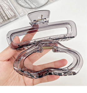 Detail of transparent gray hair claws in rectangular and wavy geometric designs