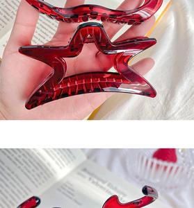 Detail of red translucent star and wave hair clips with elegant spring claw design
