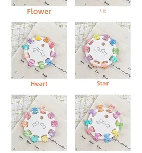 Vue macro de mini pinces à cheveux colorées en forme de fleurs et d'étoiles sur carte