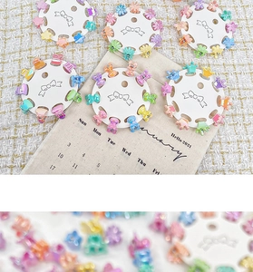 Détail de mini barrettes colorées en forme de fleurs sur un support rond blanc