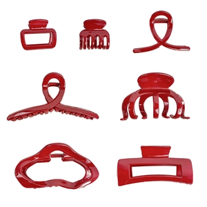 Set of seven glossy red hair claws in various shapes displayed on white background