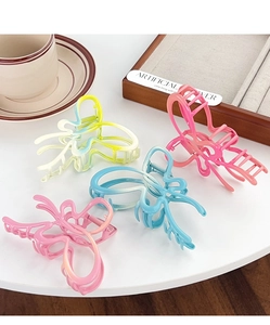 Detail view of butterfly claw clips with vibrant gradient colors and elegant metal hollow design