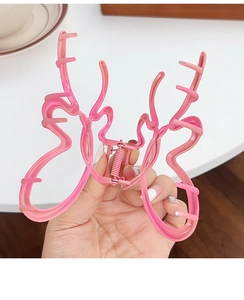 Detail of pink butterfly hair claw clip with durable metal spring and hollow design