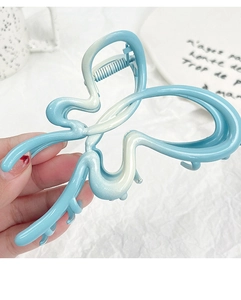 Detail shot of a matte blue and white gradient butterfly hair claw clip with alloy metal