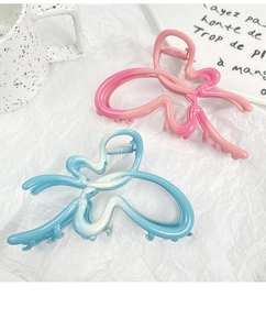 Detail of butterfly hair claw clips in pink and blue gradient with matte finish