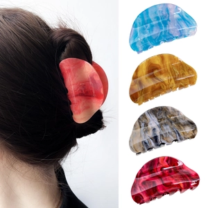 Set of four colorful acrylic star marble hair claws in blue, amber, and greyish tones
