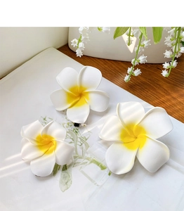 Detailed view of three plumeria flower hair clips with soft yellow gradient petals