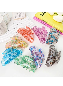Close-up of assorted pastel tortoiseshell hair claws on a decorative tray