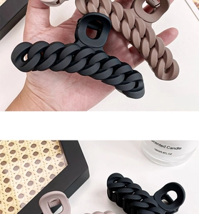 Macro detail of large matte chain-style hair claws in black and brown colors