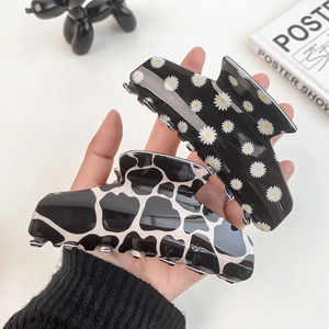 Set di due grandi mollette per capelli con motivi di margherite nere e giraffa bianca