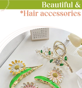 Detail of floral enamel hair claws with pearls and rhinestones in gold finish