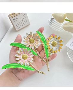 Detailed view of three large daisy flower hair claws with crystal and gold metal base