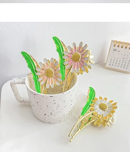 Close-up of alloy daisy hair claw clip with rhinestones and enamel flower detail