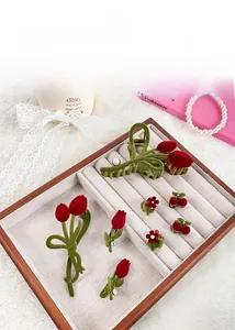 Détail de pinces à cheveux tulipe et cerise en velours avec perles sur plateau