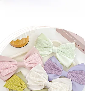 Detailansicht der Satin-Haarschleifen in Pastellfarben mit floralen Spitzenlagen