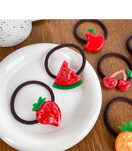 Vue détaillée de cinq élastiques à cheveux en forme de fruits comme fraise et cerise