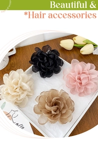 Gros plan de quatre pinces à cheveux roses en tissu noir, rose, beige et café sur plateau