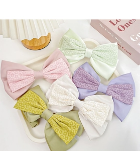 Detailansicht von fünf Satin- und Netz-Haarspangen mit Blumenmuster in Pastellfarben
