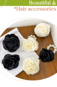 Detail of camellia hair clips and pearl scrunchies in black and cream satin fabric
