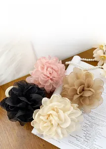 Détail de grandes pinces à cheveux fleurs en organza en rose beige noir et champagne