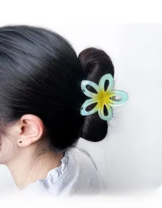 Détail d'une pince à cheveux fleur évidée avec dégradé jaune sur un chignon