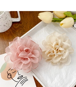 Détail macro de pinces à fleurs en tissu avec bords en fil doré en rose et beige