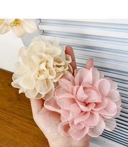 Détail de grandes pinces roses en tissu crème et rose avec des pétales en gaze multicouches