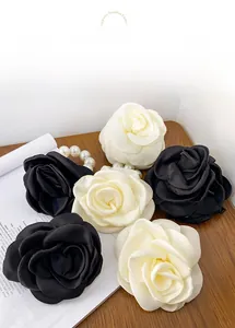 Detailed view of elegant camellia fabric hair clips in black and cream satin finish