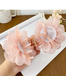 Gros plan d'une grande pince à cheveux avec fleur rose 3D en tissu multicouche
