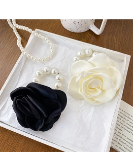 Detail of satin camellia flower hair ties with pearls in a French vintage setting