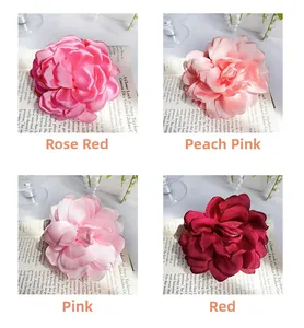 Detailed view of handmade satin flower hair clips in rose, peach, pink and red colors