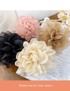 Détail de pinces à cheveux élégantes en organza avec fleurs multicouches et bordure dorée