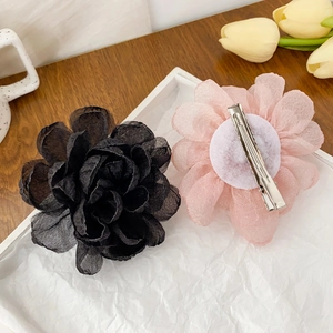 Barrettes à fleurs en tissu élégantes en rose et noir sur un fond en bois rustique