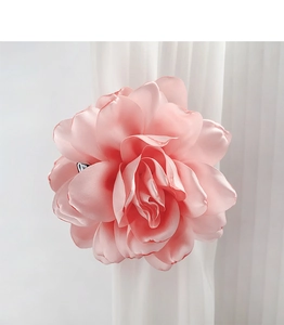 Detailed close-up of a pink silk fabric flower hair clip with layered soft petals