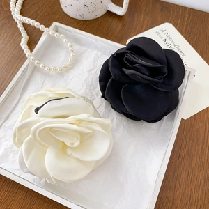 Elegant camellia flower hair claws in black and white silk fabric for a French chic style