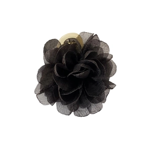 Barrette à cheveux fleur noire 3D élégante avec fermoir doré sur un fond blanc neutre