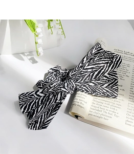 Detail of elegant black and white zebra pattern bow hair scrunchie in chic fabric texture