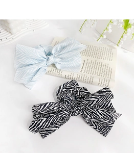 Detail of light blue and black zebra print fabric bow hair ties on a white tabletop