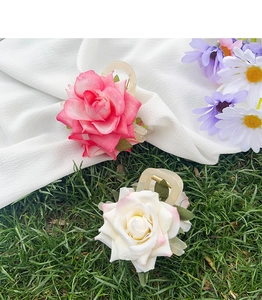 Détail des pinces à cheveux roses et blanches en forme de rose sur herbe naturelle