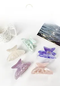 Detail view of five marble texture butterfly hair claws with elegant pearl decorations