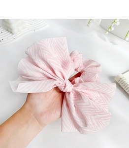 Detailed view of oversized pink zebra print bow scrunchie made of soft chiffon fabric