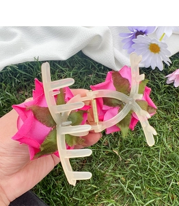 Vue détaillée d'une grande pince à cheveux avec roses en tissu rose et dents beiges
