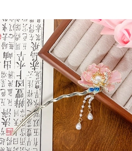 Détail d'épingle à cheveux fleur rose avec glands en perles et cristaux sur métal doré