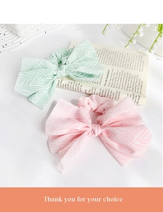 Detail of mint green and pink bow scrunchies with wavy pattern on a white tray