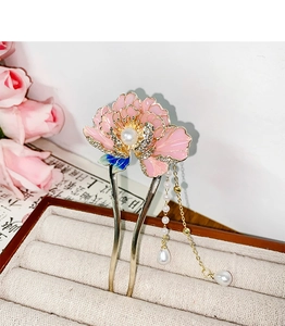 Détail d'épingle à cheveux pivoine rose avec perles et pompons sur écrin à bijoux