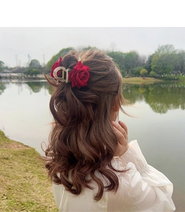 Gros plan sur la pince à cheveux rose rouge foncé portée sur une demi-coiffure