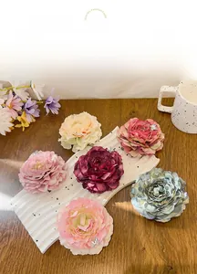 Detailed view of artificial fabric rose hair clips in six colors with butterfly charms