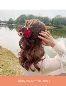 Détail d'une pince à cheveux avec roses en velours rouge pour une coiffure élégante