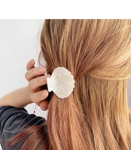 Vue détaillée de la pince à cheveux en forme de coquillage avec strass sur les cheveux