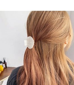 Vue détaillée d'une pince à cheveux en forme de coquillage nacré avec accents de perles